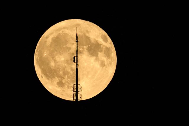 The full moon, known as the Buck Moon, raises behind the Mont Pelerin transmission tower near Forel, western Switzerland, on July 29, 2026. (Photo by Fabrice COFFRINI / AFP)