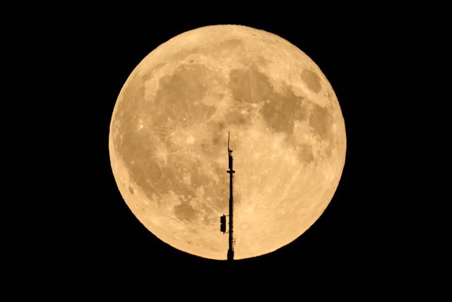 The full moon, known as the Buck Moon, raises behind the Mont Pelerin transmission tower near Forel, western Switzerland, on July 29, 2026. (Photo by Fabrice COFFRINI / AFP)