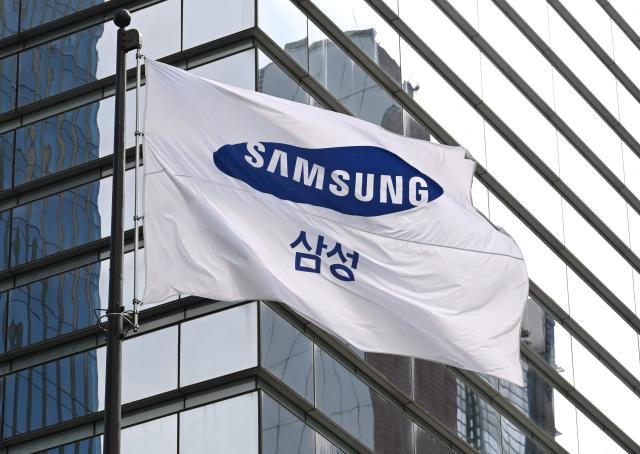 A Samsung flag flutters outside the Samsung Electronics Seocho building in Seoul on July 30, 2026. South Korean technology giant Samsung Electronics posted on July 30, a massive 19-fold jump in second-quarter operating profit from a year earlier, buoyed by sustained AI-driven demand for memory chips. (Photo by Jung Yeon-je / AFP)