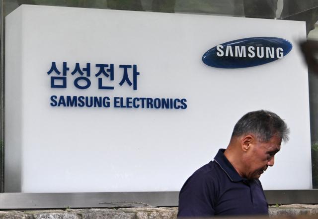 Signage of Samsung Electronics is displayed outside the company's Seocho building in Seoul on July 30, 2026. South Korean technology giant Samsung Electronics posted on July 30, a massive 19-fold jump in second-quarter operating profit from a year earlier, buoyed by sustained AI-driven demand for memory chips. (Photo by Jung Yeon-je / AFP)