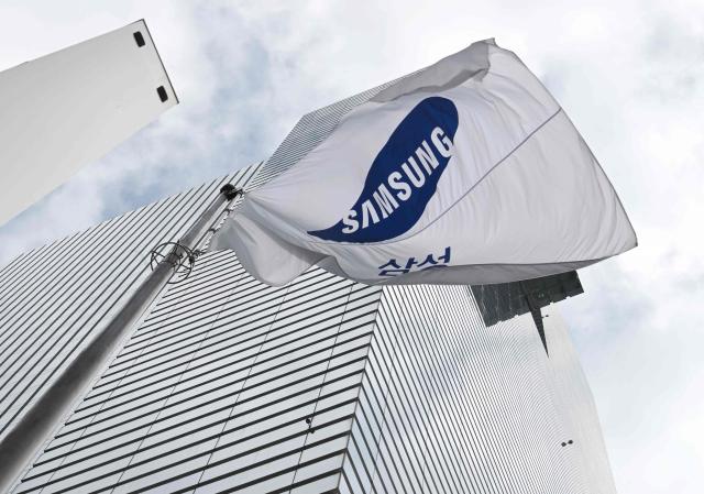 A Samsung flag flutters outside the Samsung Electronics Seocho building in Seoul on July 30, 2026. South Korean technology giant Samsung Electronics posted on July 30, a massive 19-fold jump in second-quarter operating profit from a year earlier, buoyed by sustained AI-driven demand for memory chips. (Photo by Jung Yeon-je / AFP)