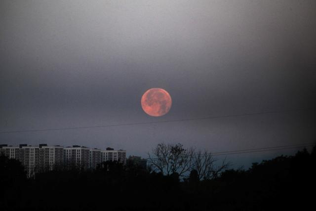 The photograph shows the moon in the smoke following Russian ballistic missile strikes over the Ukrainian capital of Kyiv on July 30, 2026, amid the Russian invasion in Ukraine. A Russian missile strike killed at least six people in central Ukraine, including two girls, the head of Kryvyi Rig's military administration said. (Photo by Sergei SUPINSKY / AFP)