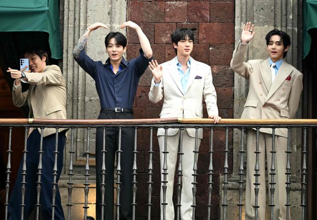 (FILES) (L-R) J-Hope, Jung Kook, Jin and V from South Korean K-pop band BTS acknowledge fans from the balcony of the National Palace at Zocalo square in Mexico City on May 6, 2026. Global K-pop sensation BTS said on July 29, 2026, they will not submit their music for next year's Grammy Awards, after the Recording Academy introduced a new Asian pop category criticised for restricting the success of regional artists. (Photo by YURI CORTEZ / AFP)