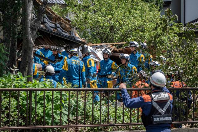 Rescue officials work at the site of a house that collapsed following the 28 July earthquake in Yatsushiro, Kumamoto prefecture on 30 July 2026. (Photo by Yuichi YAMAZAKI / AFP)