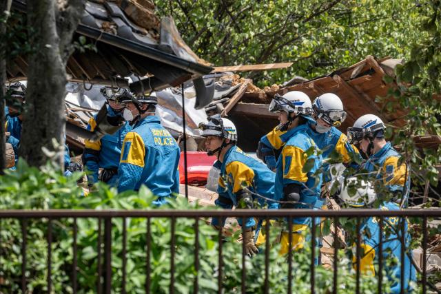 Rescue officials work at the site of a house that collapsed following the 28 July earthquake, in Yatsushiro, Kumamoto prefecture on July 30, 2026. (Photo by Yuichi YAMAZAKI / AFP)