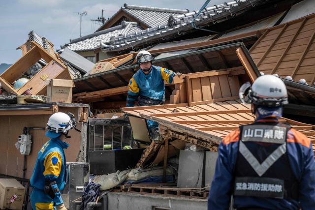 TOPSHOT - Rescue officials work at the site of a house that collapsed following the 28 July earthquake, in Yatsushiro, Kumamoto prefecture on July 30, 2026. (Photo by Yuichi YAMAZAKI / AFP)