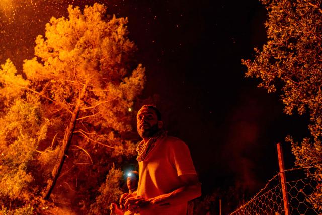 Firefighters and volunteers look on as they battle a wildfire at Seydikemer district in Mugla on July 29, 2026. Turkish firefighters on July 29, 2026, battled wildfires near the country's southern tourist beaches that have forced the evacuation of hundreds of people, authorities said. Hundreds of firefighters went up against the biggest fire in Mugla province, with more than 20 planes and helicopters bombing water on the flames, the agriculture ministry said. (Photo by Murat Kocabas / AFP)