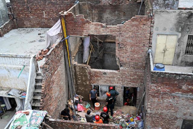 Rescue personnel conduct a search operation amid rubble after the roof of a house collapsed in Lahore on July 30, 2026. (Photo by Arif ALI / AFP)