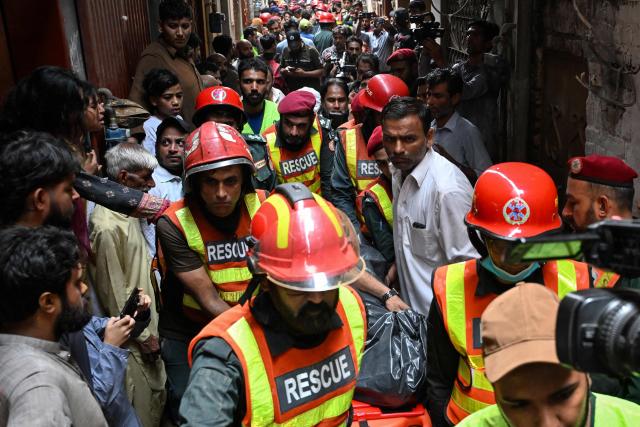 Rescue personnel carry the body of a victim recovered from rubble after the roof of a house collapsed in Lahore on July 30, 2026. (Photo by Arif ALI / AFP)