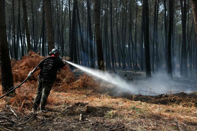 A volunteer uses water hoses to extinguishing remaining hot spots and smoldering patches in Lanton, west of Bordeaux on July 30, 2026, as a wildfire has been ravaging the forest north of the Arcachon Basin (Gironde) since July 22. After eight gruelling days battling a massive wildfire that has ravaged 42,000 hectares in Gironde (south-west France), the firefighters can see the light at the end of the tunnel, but the flare-ups observed in recent days are keeping the emergency services on tenterhooks. (Photo by ALAIN JOCARD / AFP)