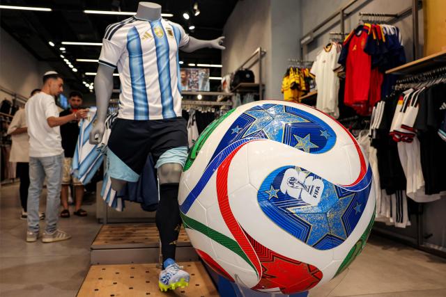 (FILES) A replica of the Adidas Trionda, the 2026 FIFA World Cup official football ball, is displayed at a sports shop in western Jerusalem on June 14, 2026. German sportswear maker Adidas missed profit expectations on July 30, 2026 after it reported results weighed by the costs of World Cup marketing, sending its shares down 17 percent. Core profit came in at 574 million euros (USD 657 million) for the three months to the end of June, Adidas said, higher than last year but about eight percent below expectations when compared to a poll of analysts by financial platform FactSet. (Photo by HAZEM BADER / AFP)