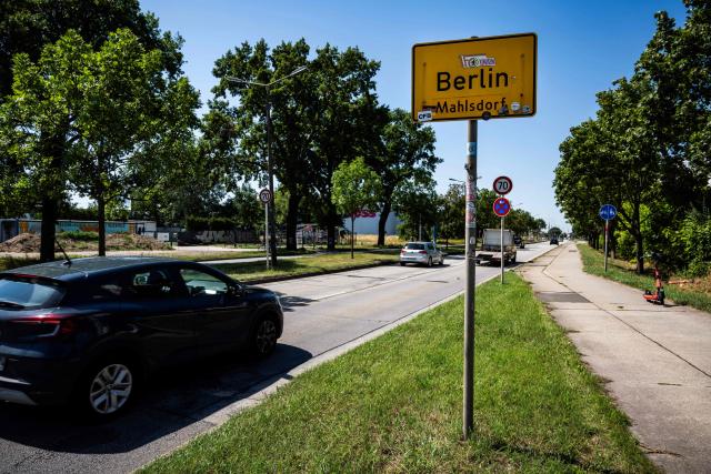 A car drives past a road sign indicating the city of Berlin's boundary with Brandenburg, in Berlin's Mahlsdorf locality, on July 30, 2026. The German capital's boundaries date back to October 1, 1920 when the Greater Berlin Act came into effect, expanding Berlin's area overnight from 66 square kilometers to nearly 880 square kilometers. (Photo by John MACDOUGALL / AFP)