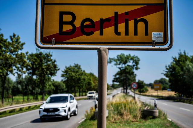 Cars drive past a road sign indicating the city of Berlin's boundary with Brandenburg, near Berlin's Mahlsdorf locality, on July 30, 2026. The German capital's boundaries date back to October 1, 1920 when the Greater Berlin Act came into effect, expanding Berlin's area overnight from 66 square kilometers to nearly 880 square kilometers. (Photo by John MACDOUGALL / AFP)