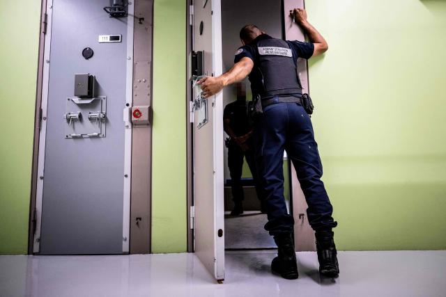 Prison officers demonstrate how to open a cell door at the third organised crime unit (drug-trafficking district) during a press tour at Reau Prison, near Paris on July 30, 2026. A third organised crime unit is set to open in France in the coming weeks, at Réau prison (Seine-et-Marne), one year after the first such unit opened in Pas-de-Calais, the prison service announced on July 30, 2026 during a press tour of the facility. (Photo by Lou BENOIST / AFP)