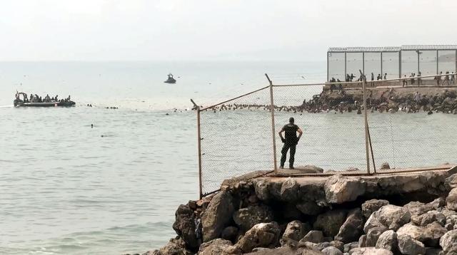 This video frame grab obtained from an AFP video shows migrants swimming in the sea to reach the shore of Spanish north African exclave of Ceuta, in Ceuta on July 30, 2026. Hundreds of migrants entered the Spanish north African exclave of Ceuta today, AFP reporters saw, many of them having swum by sea around the frontier fence. Migration from Morocco into Spain's two north African territories, Ceuta and Melilla, has long been a politically sensitive issue between the two countries, as thousands cross the border at times. AFP reporters saw a stream of adults and children, most of them wet, entering the town. (Photo by Lucía DIAZ / AFP)