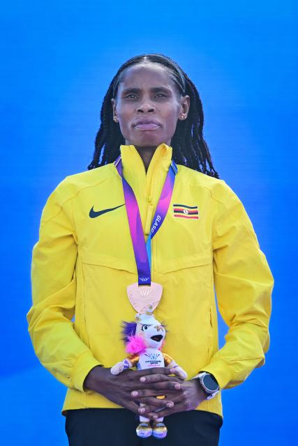 Bronze medallist Uganda's Peruth Chemutai celebrates on the podium after competing in the women's 3000m steeplechase during the athletics event at the Scotstoun Stadium in Glasgow, on day seven of the Commonwealth Games in Glasgow, Scotland, on July 30, 2026. (Photo by ANDY BUCHANAN / AFP)