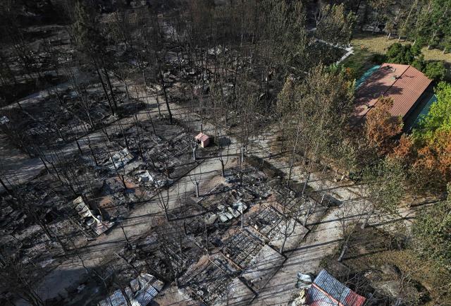 Aerial view of burnt pitches at the Valle de Iruelas camping, near El Tiemblo, in Avila province, Spain on July 30, 2026. Spanish Prime Minister Pedro Sanchez today lifted the state of emergency over the wildfires in Madrid and Avila regions that forced the evacuations of tens of thousands of people. Wildfires have stopped spreading and there are "almost no flames", Spanish authorities said. But they warned that the ongoing heatwave threatens a resurgence of fire in areas west of Madrid, where more than 25,000 hectares (61,776 acres) have already gone up in smoke. (Photo by OSCAR DEL POZO / AFP)