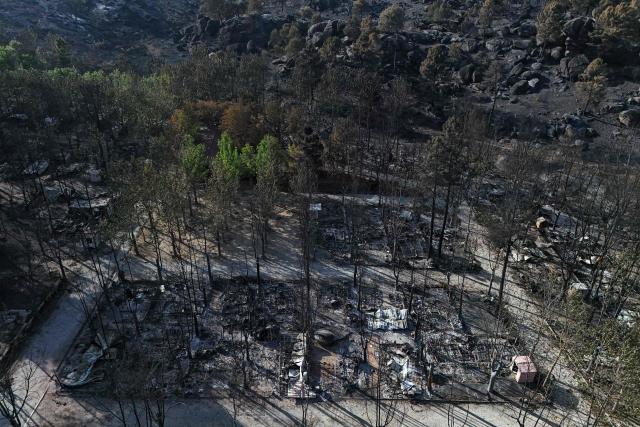Aerial view of burnt pitches at the Valle de Iruelas camping, near El Tiemblo, in Avila province, Spain on July 30, 2026. Spanish Prime Minister Pedro Sanchez today lifted the state of emergency over the wildfires in Madrid and Avila regions that forced the evacuations of tens of thousands of people. Wildfires have stopped spreading and there are "almost no flames", Spanish authorities said. But they warned that the ongoing heatwave threatens a resurgence of fire in areas west of Madrid, where more than 25,000 hectares (61,776 acres) have already gone up in smoke. (Photo by OSCAR DEL POZO / AFP)