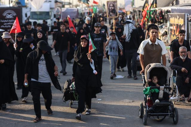 Shia pilgrims march through Baghdad's Dora district towards Karbala to take part in the Arbaeen pilgrimage on July 30, 2026. The Arbaeen marks one of the most significant events in the Shia Muslim calendar, during which pilgrims, many from Iran, flock to Iraq to visit the holy shrines. (Photo by AHMAD AL-RUBAYE / AFP)