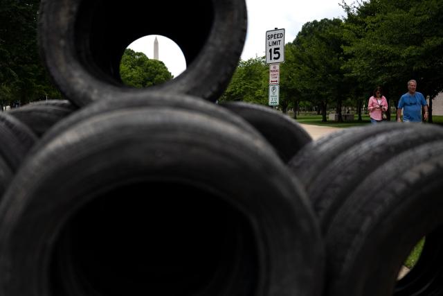 Visitors walk past piles of tires that will be used as protective walls for the Freedom 250 Grand Prix along the National Mall in Washington, DC on July 30, 2026. The Freedom 250 Grand Prix is an IndyCar Series races scheduled for August 22–23, 2026 around the National Mall, to celebrate the 250th anniversary of the US Independence. (Photo by Kent Nishimura / AFP)