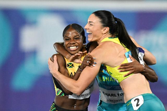 Australia's Michelle Jenneke (R) congratulates second-placed Jamaica's Megan Simmonds (L) and winner Bahamas' Devynne Charlton after competing in the women's 100m hurdles final during the athletics event at the Scotstoun Stadium in Glasgow, on day seven of the Commonwealth Games in Glasgow, Scotland, on July 30, 2026. (Photo by ANDY BUCHANAN / AFP)