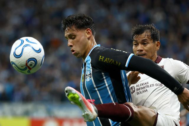 Gremio's Peruvian midfielder #19 Erick Noriega and Bolivar's defender #04 Jose Sagredo fight for the ball during the second leg of the Copa Sudamericana knockout round play-off football match between Brazil's Gremio and Bolivia's Bolivar at the Arena do Gremio stadium in Porto Alegre, state of Rio Grande do Sul, Brazil, on July 30, 2026. (Photo by SILVIO AVILA / AFP)