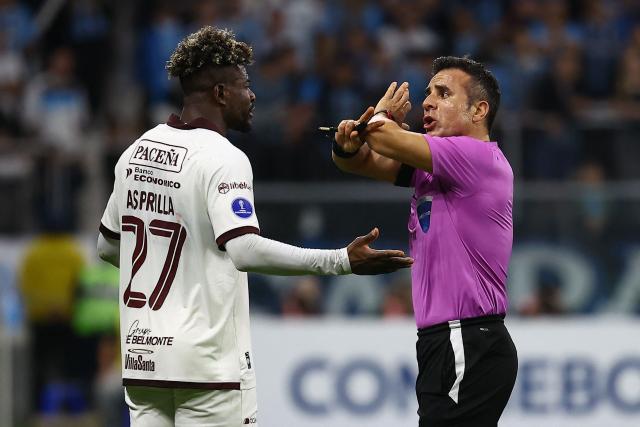 Chilean referee Piero Maza speaks with Bolivar's Colombian forward #17 Dairon Asprilla during the second leg of the Copa Sudamericana knockout round play-off football match between Brazil's Gremio and Bolivia's Bolivar at the Arena do Gremio stadium in Porto Alegre, state of Rio Grande do Sul, Brazil, on July 30, 2026. (Photo by SILVIO AVILA / AFP)