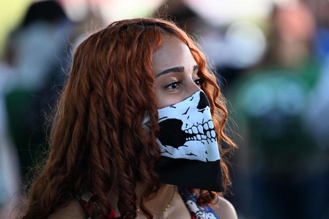 A demonstrator wearing a skull-pattern face covering takes part in a march marking the 51st anniversary of the 1975 Salvadoran student massacre in San Salvador on July 30, 2026. On July 30, 1975, a protest march against the military occupation of a campus of the state-run University of El Salvador (UES) was dispersed by police using armored vehicles and gunfire during the administration of late Colonel Arturo Armando Molina (1972-1977), with university authorities reporting that around 50 students were killed and dozens disappeared. (Photo by Marvin RECINOS / AFP)