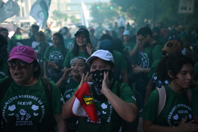 Demonstrators take part in a march to commemorate the 51st anniversary of the 1975 Salvadoran student massacre in San Salvador on July 30, 2026. On July 30, 1975, a protest march against the military occupation of a campus of the state-run University of El Salvador (UES) was dispersed by police using armored vehicles and gunfire during the administration of late Colonel Arturo Armando Molina (1972-1977), with university authorities reporting that around 50 students were killed and dozens disappeared. (Photo by Marvin RECINOS / AFP)