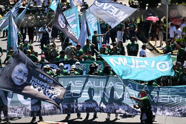 Demonstrators take part in a march to commemorate the 51st anniversary of the 1975 Salvadoran student massacre in San Salvador on July 30, 2026. On July 30, 1975, a protest march against the military occupation of a campus of the state-run University of El Salvador (UES) was dispersed by police using armored vehicles and gunfire during the administration of late Colonel Arturo Armando Molina (1972-1977), with university authorities reporting that around 50 students were killed and dozens disappeared. (Photo by Marvin RECINOS / AFP)