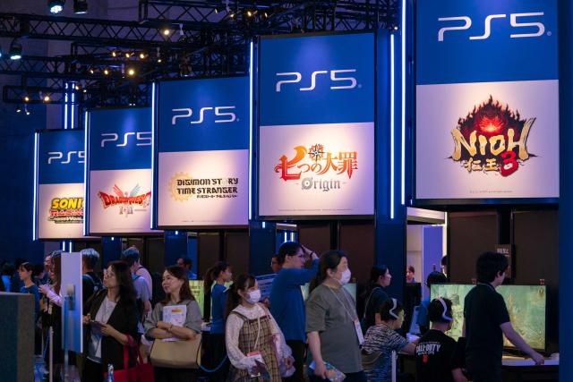 (FILES) Visitors walk in front of the booth for Sony's PlayStation during the preview day for the annual Tokyo Game Show at Makuhari Messe in Chiba City, Chiba Prefecture on September 25, 2025. Sony hiked its profit forecasts for the current year on July 31, 2026, banking on improved earnings in the Japanese consumer electronics giant's video games division and the weak yen. (Photo by Kazuhiro NOGI / AFP)