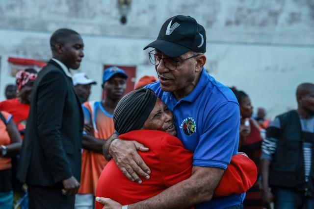 TOPSHOT - Carlos Vila Nova (C), President of the Democratic Republic of Sao Tome and Principe, is hugged by a supporter, in Santo Antonio city, in Príncipe on July 30, 2026. (Photo by Daniel BELOUMOU OLOMO / AFP)