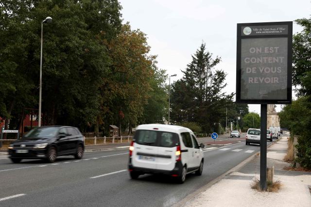 An illuminated sign of the Saint Jean d'Illac town hall welcomes residents returning home after being evacuated due to the wildfire in Saint Jean d’Illac, in the Gironde region, south-western France, on July 31, 2026. After nine days of fierce firefighting efforts and 42,000 hectares of forest lost to the flames, optimism prevails regarding the Gironde mega-fire; while it is contained within its perimeter, it remains active in places, preventing it from being declared "stabilized." (Photo by ROMAIN PERROCHEAU / AFP)