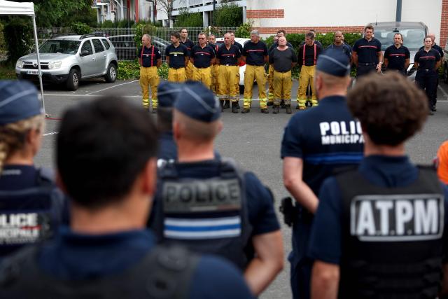 Police officers joined firefighters during a moment of respect for the memory of their comrades killed while combatting a forest fire in Merignac three days before, at their base in Lège-Cap-Ferret, near Bordeaux, on July 31, 2026. (Photo by ROMAIN PERROCHEAU / AFP)