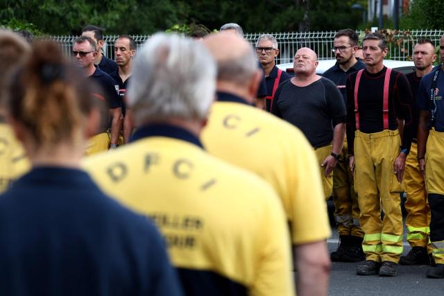 Firefighters stand in silence during a moment of respect for the memory of their comrades killed while combatting a forest fire in Merignac three days before, at their base in Lège-Cap-Ferret, near Bordeaux, on July 31, 2026. (Photo by ROMAIN PERROCHEAU / AFP)