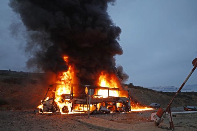A vehicle burns at the site of clashes near Fnideq, on the Morocco-Spain border, on July 31, 2026. Thousands of migrants crossed overnight from Morocco into Spain's north Africa's Ceuta enclave, a police source said on July 31, adding that it was impossible to estimate how many people in total. A total of 18 people died while attempting to reach the Spanish enclave, the source said. (Photo by Abdel Majid BZIOUAT / AFP)