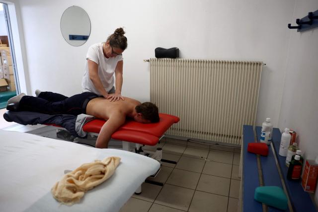 A firefighter receives treatment from a physiotherapist in Lège-Cap-Ferret, near Bordeaux, on July 31, 2026. Fire-ravaged southwestern France experienced its "first somewhat optimistic day" since wildfires broke out more than a week ago, a top local official said on July 30. French firefighters have battled wildfires for more than a week in the Gironde region which forced the evacuation of 220,000 people and killed two firemen. The blazes have destroyed more than 200 homes and 42,000 hectares (104,000 acres). (Photo by ROMAIN PERROCHEAU / AFP)
