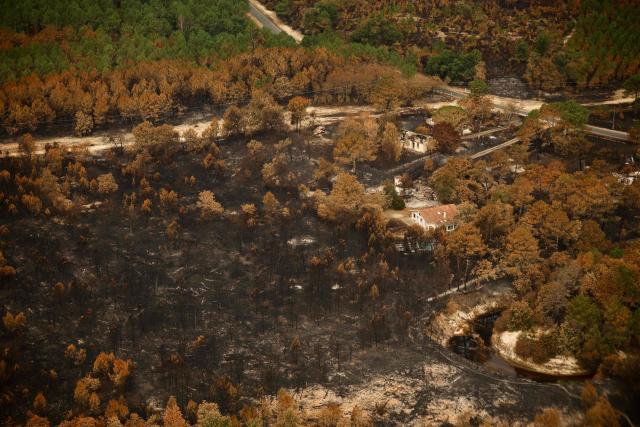 This aerial photograph taken from a French Civil Security rescue coordination helicopter shows a partially burnt residential area in Le Porge, south-western France on July 31, 2026, as a wildfire has been ravaging the forest north of the Arcachon Basin (Gironde) since July 22. (Photo by Sarah Meyssonnier / POOL / AFP)