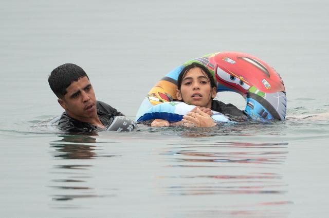 Migrants swim around a border barrier with Morocco to enter Spain's north Africa's Ceuta enclave on July 31, 2026. Thousands of migrants crossed overnight from Morocco into Ceuta enclave, a police source said, as Spanish Prime Minister was set to arrive to manage the latest migrant crisis on the border. In recent days, a total of around 40,000 migrants have crossed into the territory, population 80,000, the source added. (Photo by JORGE GUERRERO / AFP)