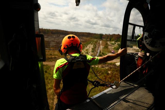 A member of Civil Security watches their surroundings aboard a French Civil Security rescue coordination helicopter in Le Porge, south-western France on July 31, 2026, as a wildfire has been ravaging the forest north of the Arcachon Basin (Gironde) since July 22. (Photo by Sarah Meyssonnier / POOL / AFP)