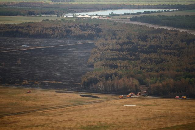 This aerial photograph taken from a French Civil Security rescue coordination helicopter shows a partially burnt wooden area in Le Porge, south-western France on July 31, 2026, as a wildfire has been ravaging the forest north of the Arcachon Basin (Gironde) since July 22. (Photo by Sarah Meyssonnier / POOL / AFP)