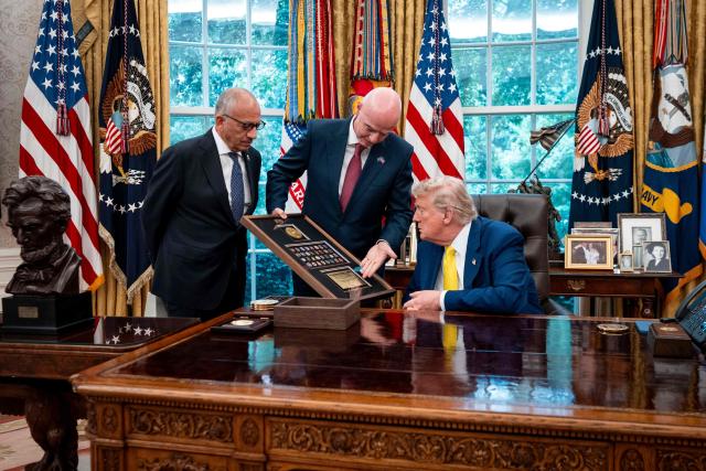 (FILES) (L/R): then former president of the United States Soccer Federation Carlos Cordeiro looks on as FIFA President Gianni Infantino presents US President Donald Trump with a gift in the Oval Office of the White House during a visit by members of Italian soccer club Juventus in Washington, DC, on June 18, 2025. The Asian Football Confederation (AFC) joined UEFA and CONCACAF in condemning world football's governing body FIFA's proposed private investment plan, saying on July 31, 2026, that they were alarmed it had reached the point a "World Cup boycott has entered public discourse". A damaging blow to FIFA president Gianni Infantino came with the later resignation of a senior advisor Carlos Cordeiro, who issued an excoriating statement. (Photo by Doug Mills / POOL / AFP)