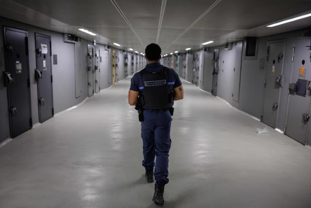(FILES) A penitentiary administration police officers patrols in the corridor at the men's remand wing at the Fleury-Merogis prison in Fleury-Merogis, outside Paris on July 16, 2026. French prisons held 89,446 inmates as of July 1, 2026, a new record amidst chronic overcrowding, according to official Ministry of Justice statistics consulted by AFP on July 31, 2026. (Photo by SIMON WOHLFAHRT / AFP)