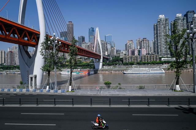 This picture taken on July 21, 2026 shows a man riding his motorcycle along a street in Chongqing, southwestern China. The roar of engines fills the night air in China's Chongqing city as tourists awkwardly clamber onto gleaming motorbikes and cling to muscular drivers to star in personalised videos. (Photo by WANG Zhao / AFP) / To go with 'CHINA-MOTORBIKE-INTERNET,FOCUS' by Sam DAVIES