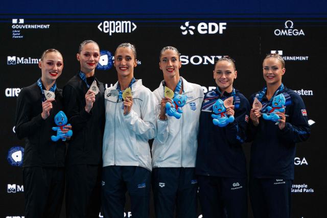 (From L) Silver medallists Neutral Athletes artistic swimmers Maiia Doroshko and Elizaveta Minaeva, gold medallists Greece's artistic swimmers Anna Maria Alexandri and Eirini Marina Alexandri and bronze medallists Britain's artistic swimmers Kate Shortman and Isabelle Thorpe pose on the podium following the duet technical artistic swimming final event during the LEN European Aquatics Championships at the Olympic Aquatics Centre in Saint-Denis, northeastern suburbs of Paris, on July 31, 2026. (Photo by Dimitar DILKOFF / AFP)