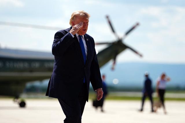 US President Donald Trump salutes before borading Air Force One while departing Hagerstown Regional Airport in Washington County, Maryland, on July 31, 2026, following a Cabinet meeting at Camp David. (Photo by Aaron Schwartz / AFP)