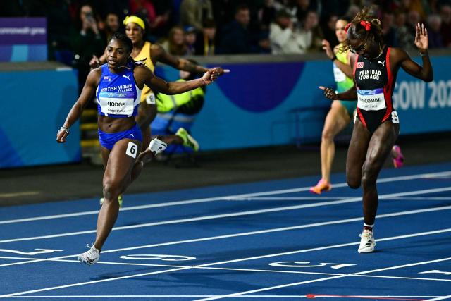 British Virgin Islands' Adaejah Hodge (L) celebrates as she crosses the finish line past Trinidad and Tobago's Shaniqua Bascombe (R), to win in the women's 200m final during the athletics event at the Scotstoun Stadium in Glasgow, on day eight of the Commonwealth Games in Glasgow, Scotland, on July 31, 2026. (Photo by Ben STANSALL / AFP)