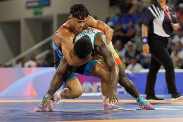 Bahamas’ Shannon Geran Hanna and Peru’s Joseph Andres Silva take part in the men’s Greco-Roman 65kg wrestling final during the XXV Central American and Caribbean Games in Santo Domingo on July 31, 2026. (Photo by Francesco SPOTORNO / AFP)