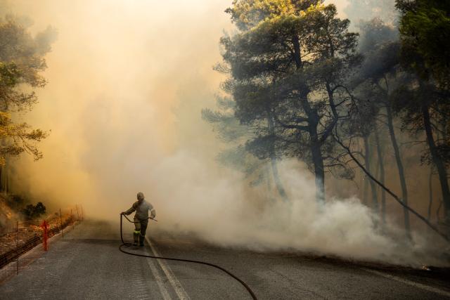 A Greek firefighter tries to extinguish a wildfire in the area of Porto Germeno, some 70 kilometres (45 miles) northwest of Athens in the region of Viotia, on August 2, 2026. Hundreds of firefighters in Greece battle to save a popular coastal resort northwest of Athens as violent winds continued to lash the country, hampering operations. Hit hard by the climate crisis like the rest of the Mediterranean region, the country is plagued by wildfires every summer due to high temperatures, frequent heatwaves, and drought. (Photo by Angelos TZORTZINIS / AFP)