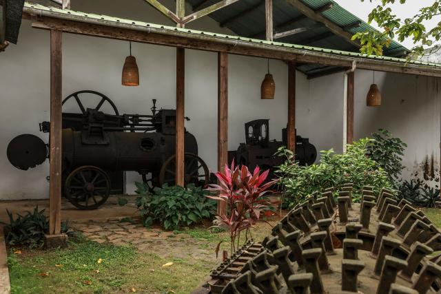 General view of old steam engine and other tools used on the Roça Sundy, near Santo Antonio, in Príncipe Island in São Tomé and Príncipe, on  August 1, 2026. Located on Príncipe island, Roça Sundy is famous both for its cocoa production and the historical site where Arthur Eddington conducted observations proving Einstein's theory of general relativity. It is one of six roças recognized as UNESCO World Heritage sites. The Roças are historic agricultural plantations in São Tomé and Príncipe that were established by the Portuguese in the 19th and 20th centuries for coffee and cocoa production. Operating as self-sufficient, hierarchical complexes, they included processing factories, housing (sanzalas), hospitals, and railways. (Photo by Daniel BELOUMOU OLOMO / AFP)
